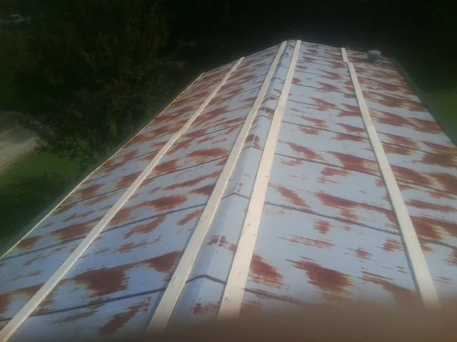Rusted metal roof panels with new wood purlins before replacement — Storm Damage Roof Repair in Capac by Roofing Brothers