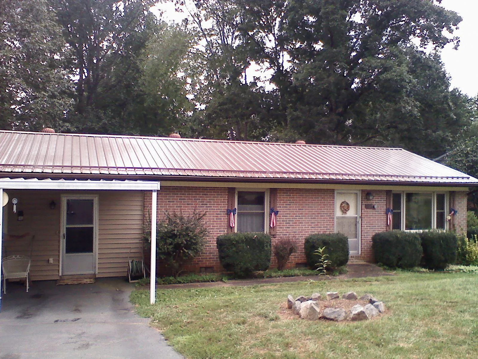 Bronze metal roof and carport on a brick ranch home — Roof Repair work by our crew in Capac